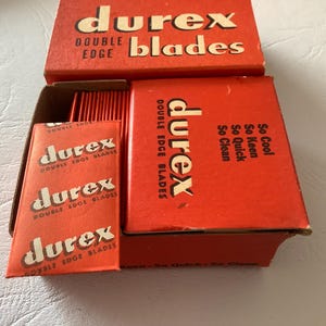 Może przedstawiać: Zestaw vintage ostrzy do golenia Durex z podw&oacute;jnym ostrzem w czerwonym opakowaniu. Pudełka i indywidualne opakowania ostrzy zawierają logo i tekst Durex. Opakowanie zawiera frazy "So Cool, So Keen, So Quick, So Clean."
