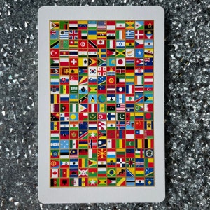 May include: A white card with a grid of colorful flags from around the world. The flags are arranged in a grid pattern and are all different sizes. The card is surrounded by a white border.