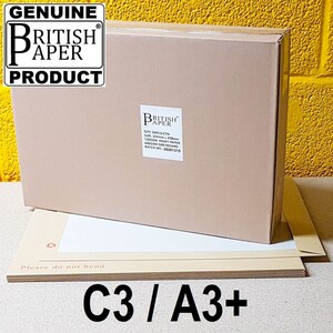 May include: A brown cardboard box with a white label that says "GENUINE BRITISH PAPER PRODUCT" and a smaller white label that says "BRITISH PAPER" with the text "QTY: 50PCS/CTN SIZE: 324mm x 458mm 120GSM KRAFT PAPER 600GSM GREYBOARD BATCH NO: 20201215". The box is sitting on top of a stack of brown paper sheets with the text "Please do not bend" and "C3/A3+" printed on them.