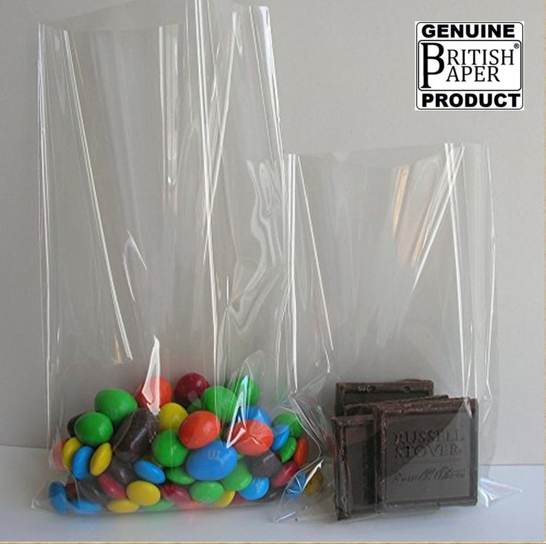 May include: Two clear plastic bags, one larger than the other, filled with colourful candy and chocolate bars. The bags are made by Genuine British Paper Products.