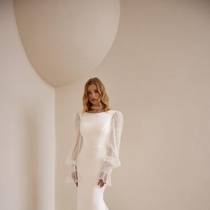 Elegante vestido de novia de crepé de manga larga con escote alto, corte sirena y cola extendida: vestido de novia clásico y moderno