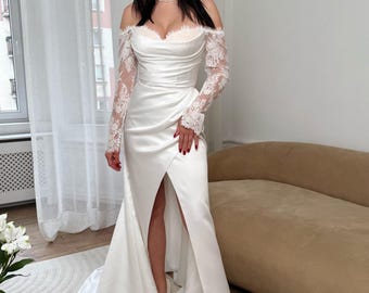 May include: A white satin wedding dress with a sweetheart neckline and off-the-shoulder lace sleeves. The dress features a high slit and a flowing train. The model is wearing white heels. The dress is elegant and suitable for a wedding.