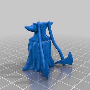 Puede incluir: Un yunque en miniatura de plástico azul con dos hachas de plástico azul apoyadas en él. El yunque tiene un diseño decorativo en la parte delantera.