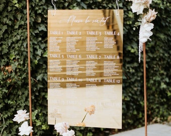 May include: A gold mirror with a copper frame and stand, displaying a wedding seating chart with the text "Please be seated" and table numbers 1 through 12.