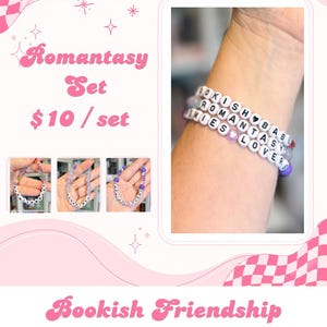 May include: A set of three beaded bracelets featuring white letter beads spelling out BOOKISH BABE, ROMANTASY, and LIES LOVER. The bracelets are accented with purple, pink, and clear beads, including a small heart-shaped bead on one of the strands.