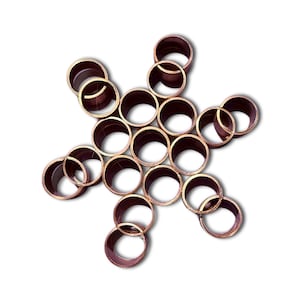 May include: A cluster of nineteen circular copper-colored metal rings arranged in a hexagonal pattern. Each individual ring features a smooth, metallic finish with a hollow center, joined together to form a single, unified geometric structure.