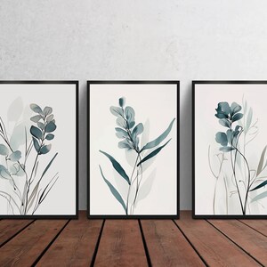 May include: Set of three framed watercolor prints featuring abstract floral designs in shades of blue and green on a white background.