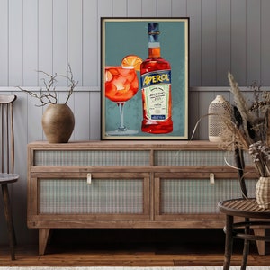 K&ouml;nnte beinhalten: Ein Vintage-Poster mit einer Flasche Aperol, einem italienischen Lik&ouml;r, und einem Glas Aperol Spritz. Das Poster hat einen blauen Hintergrund mit einem wei&szlig;en Rand und den Text "Aperol Aperitivo 1919" in wei&szlig;.