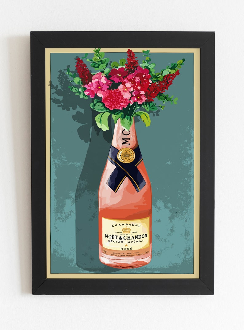 May include: A framed vintage poster featuring a bottle of Mo&euml;t & Chandon Nectar Imperial Ros&eacute; champagne with a bouquet of pink flowers in the background. The poster has a teal background with a white border.