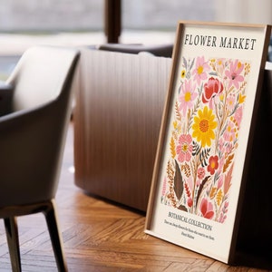 May include: A framed print with a floral design featuring pink, yellow, and red flowers. The print is titled "Flower Market" and includes the text "Botanical Collection".