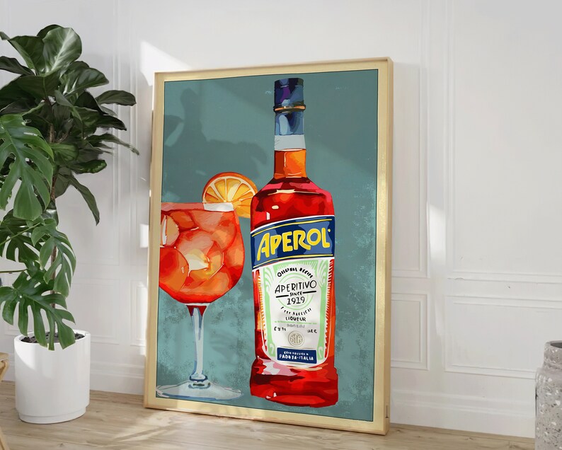 K&ouml;nnte beinhalten: Ein Vintage-Poster mit einer Flasche Aperol, einem italienischen Aperitif, und einem Glas Aperol Spritz. Das Poster hat einen blauen Hintergrund mit einer roten und wei&szlig;en Flasche und einem Glas mit orangefarbener Fl&uuml;ssigkeit.