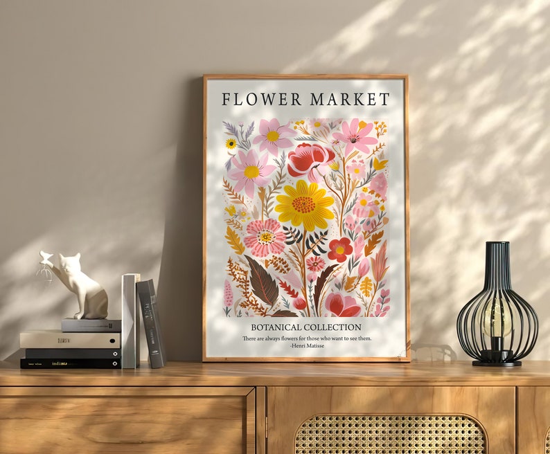 May include: A framed print with a floral design featuring pink, yellow, and red flowers. The print has the text "FLOWER MARKET" and "BOTANICAL COLLECTION" with a quote by Henri Matisse.