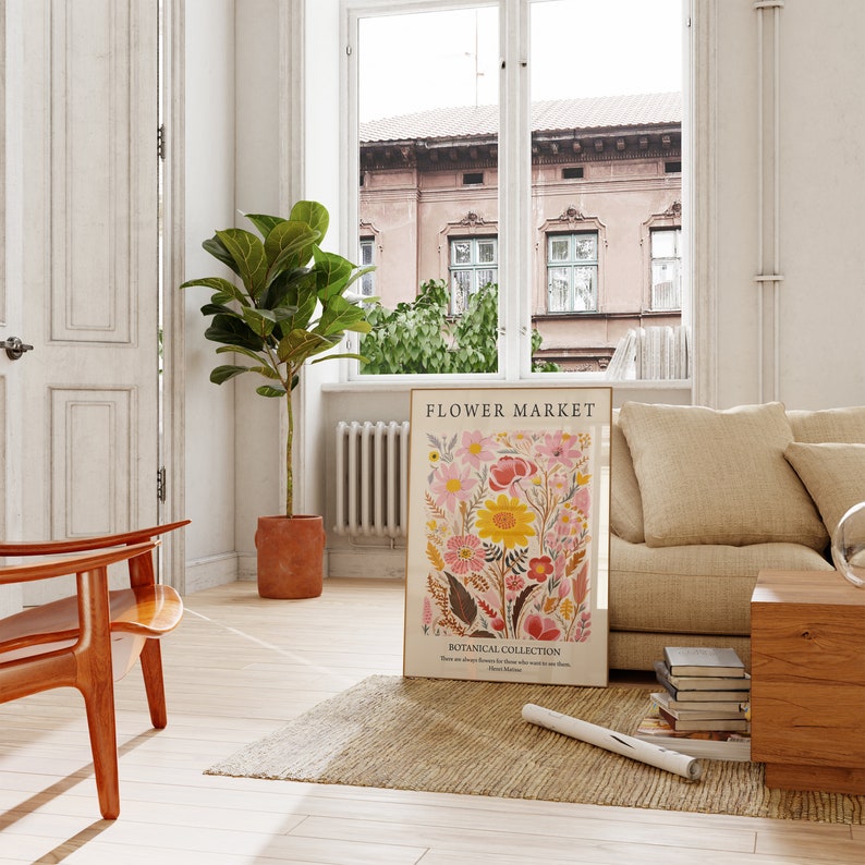 May include: A floral print poster with the title "FLOWER MARKET" and the text "BOTANICAL COLLECTION" in a living room setting with a couch, a chair, a plant, and a rug.