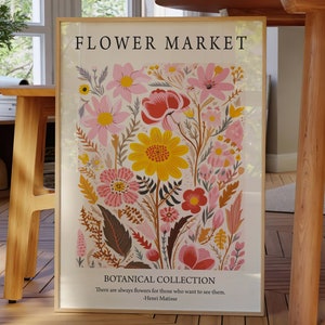 May include: A framed print with a floral design featuring pink, yellow, and red flowers. The print has the text "FLOWER MARKET" and "BOTANICAL COLLECTION" with a quote by Henri Matisse: "There are always flowers for those who want to see them."
