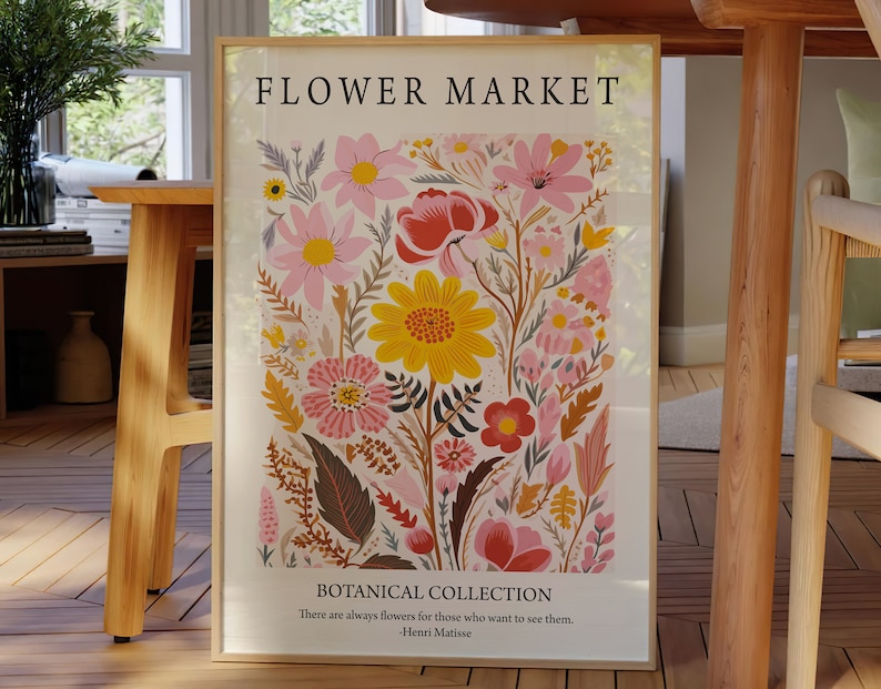 May include: A framed print with a floral design featuring pink, yellow, and red flowers. The print has the text "FLOWER MARKET" and "BOTANICAL COLLECTION" with a quote by Henri Matisse: "There are always flowers for those who want to see them."