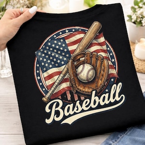 Peut inclure: T-shirt noir avec un motif de baseball. Le design comprend une balle de baseball, un gant et une batte sur fond de drapeau américain, avec le mot "Baseball" en police stylisée.
