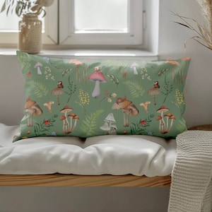 May include: A green throw pillow with a mushroom and fern pattern. The pillow features a variety of mushrooms in different colors and sizes, as well as green ferns and other foliage.