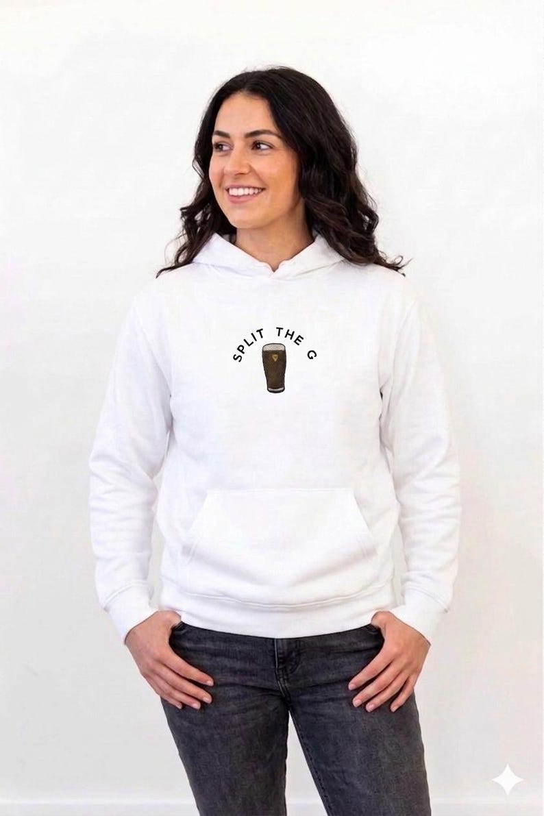 May include: White hoodie with a front pocket and the text "SPLIT THE G" above a graphic of a pint of stout. The hoodie is worn by a person with dark hair and is paired with dark jeans.