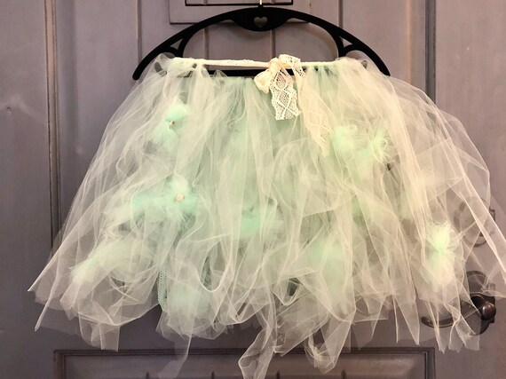 This kids Tutu in spring green with flowers and lace is a perfect gift or just a fun item to play in. It is handmade from polyester tulle and lace. All proceeds go to support cancer patients. We make similar items to bring to Children&#39;s Hospital for the kids going through treatment there and for fundraising events with partner organizations like Children&#39;s.