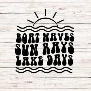 May include: Black and white graphic design with the words "BOAT WAVES SUN RAYS LAKE DAYS" in a retro font. The design includes a sun, waves, and a wooden background.