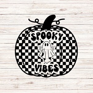 May include: A black and white chequered pumpkin design with the words "Spooky Vibes" and a ghost making a peace sign. The pumpkin has a stem and is set against a white wood background.