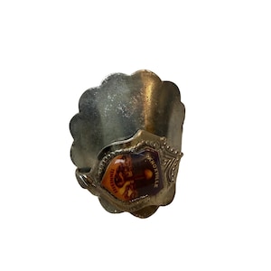 Puede incluir: Servilletero de metal plateado con borde festoneado. El anillo presenta un emblema rectangular con el texto "Knoxville Tennessee" y una imagen colorida de un edificio.