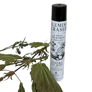 May include: A white and black cylindrical bottle labeled "Blemish Eraser & Spot Treatment Roller" with "Jojoba Oil Base" text. The bottle has a black cap and is next to dried green leaves. The bottle contains 0.34 fl oz.