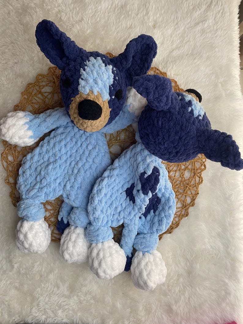 May include: Two crocheted stuffed toys in the shape of dogs. One is blue with white spots and the other is light blue with dark blue spots. Both have white crocheted feet.