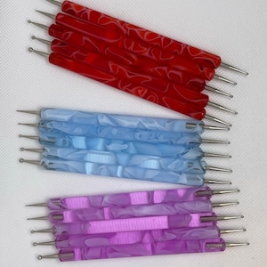 May include: Set of 18 nail art dotting tools with different sized ball tips. The tools have red, blue, and purple swirl patterned handles.