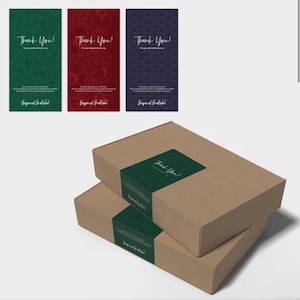 May include: Two stacked rectangular cardboard shipping boxes featuring a dark green paper band with the text Thank You and Beyond Grateful. Above are three vertical thank you cards in green, red, and blue with floral and geometric patterns.