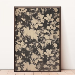 May include: A framed print with a black and white floral pattern. The flowers are a light beige color and are arranged in a random pattern.