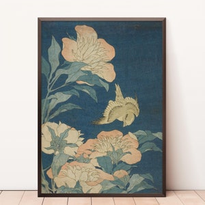 Puede incluir: Una impresión japonesa vintage en madera que representa un pájaro volando sobre un grupo de peonías rosas y blancas sobre un fondo azul.