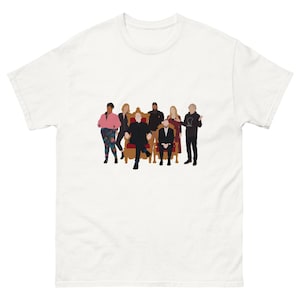 May include: White t-shirt with a group illustration. The figures are depicted in a minimalist style, with solid colors. A throne-like chair is in the center. The people are standing and sitting. The design is simple and modern.