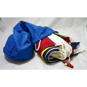 以下が含まれることがあります： 青い巾着袋に入った航海信号旗のセット。旗は折り畳まれ、白いロープで束ねられています。旗は赤、白、青、黄色の色です。