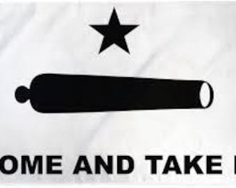 May include: White flag with a black cannon and star design. The text "COME AND TAKE IT" is printed in black at the bottom. The flag is rectangular and appears to be made of fabric.