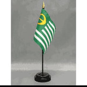 May include: A green and yellow desk flag with a crescent moon and a circle on a black stand.