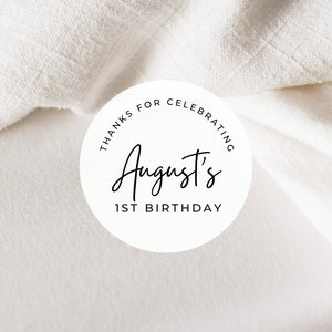 May include: White round sticker with black text that says "Thanks for celebrating August's 1st Birthday."