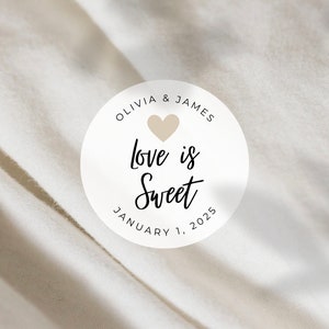 May include: White circle sticker with the text "Olivia & James Love is Sweet January 1, 2025" and a small beige heart.