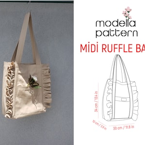 May include: A beige tote bag with ruffle trim and a small pocket on the front. The bag is 13.4 inches tall, 11.8 inches wide, and 3.9 inches deep.  The bag is hanging from a hook.