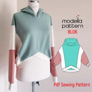 May include: A colour-blocked hoodie in mint green, white, and dusty rose displayed on a mannequin. The hoodie features a hood and long sleeves. The image also includes a pattern illustration and the text "modella pattern BLOK" and "Pdf Sewing Pattern."
