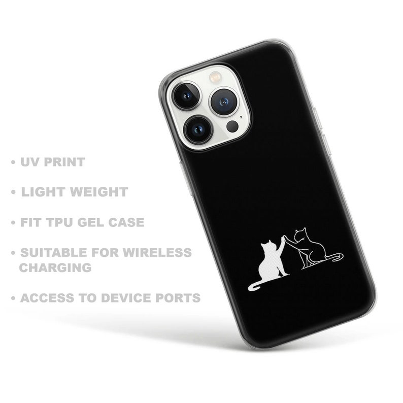 Puede incluir: Una funda de tel&eacute;fono negra con la parte posterior transparente y un contorno blanco de dos gatos d&aacute;ndose la mano. La funda es compatible con la carga inal&aacute;mbrica.
