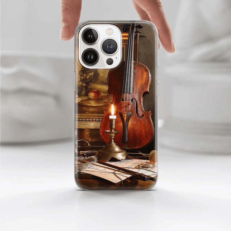 K&ouml;nnte beinhalten: Eine transparente Handyh&uuml;lle mit einem Vintage-Bild eines Violins, einer brennenden Kerze und Noten. Die Violine ist braun und hat einen warmen, goldenen Farbton. Die Kerze steht in einem Messing-Kerzenleuchter und wirft einen warmen Schein auf die Szene.