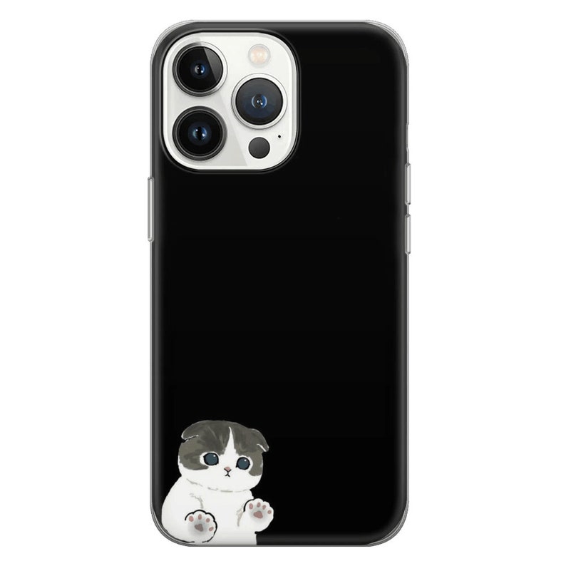 Puede incluir: Una funda de tel&eacute;fono negra con la parte posterior transparente y una ilustraci&oacute;n de un gato blanco. El gato mira hacia la izquierda y tiene la nariz y los ojos negros.