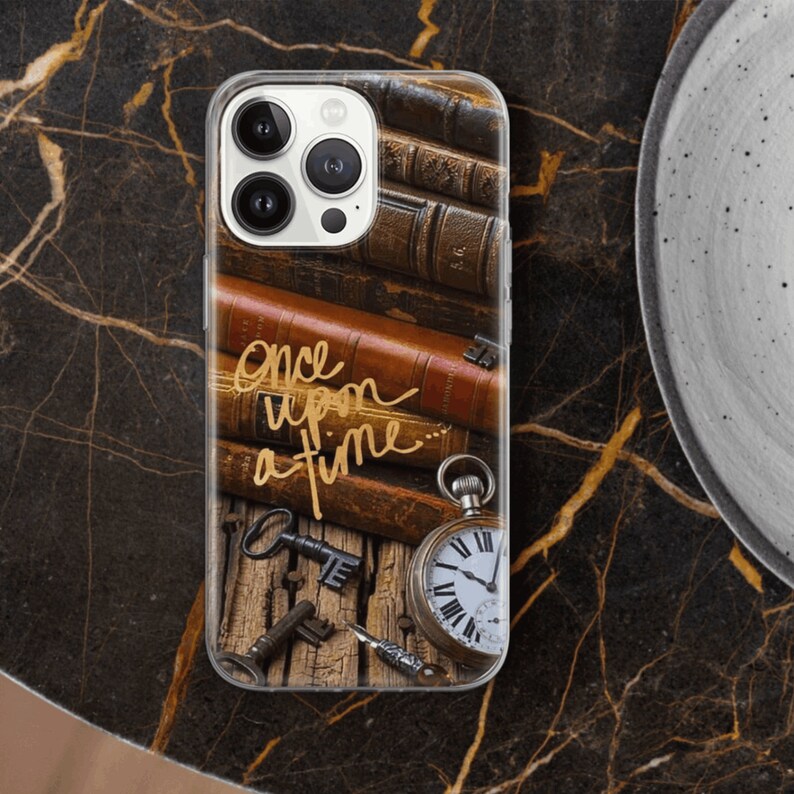 May include: A clear phone case with a vintage design featuring stacked leather-bound books, an antique pocket watch, and keys. The text "once upon a time" is written in gold script.