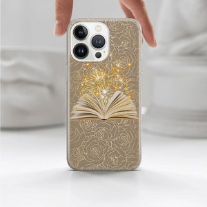 May include: A clear phone case with a gold design of roses and an open book with sparkling lights coming from it.