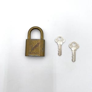 May include: A gold padlock with the text "Jarvis Walker Rustless" on the front. Two silver keys with the text "Jarvis Walker" on them.