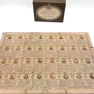 May include: A brown cardboard box labeled Wallis's Royal Chronological Tables of English History and a matching rectangular puzzle board featuring a grid of historical portraits and text detailing English monarchs in a vintage style.