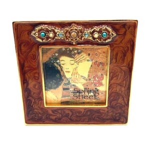 May include: A decorative picture frame with a brown, swirled pattern and gold trim. The frame features a painting with the text "Spring Street". The frame is adorned with turquoise and gold accents.