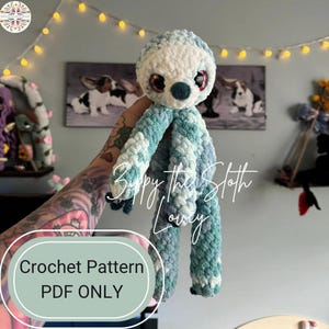 Pode incluir: Um padrão de crochê para um brinquedo amigurumi de preguiça azul e branco. O padrão está disponível apenas como download em PDF. O texto "Zippy the Sloth Lovey" é visível na imagem.