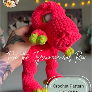 May include: A bright pink crocheted Tyrannosaurus Rex toy with lime green accents on its feet and claws. The toy has large, round eyes and is labeled "Poe the Tyrannasaurus Rex". The image also includes the text "Crochet Pattern PDF ONLY".